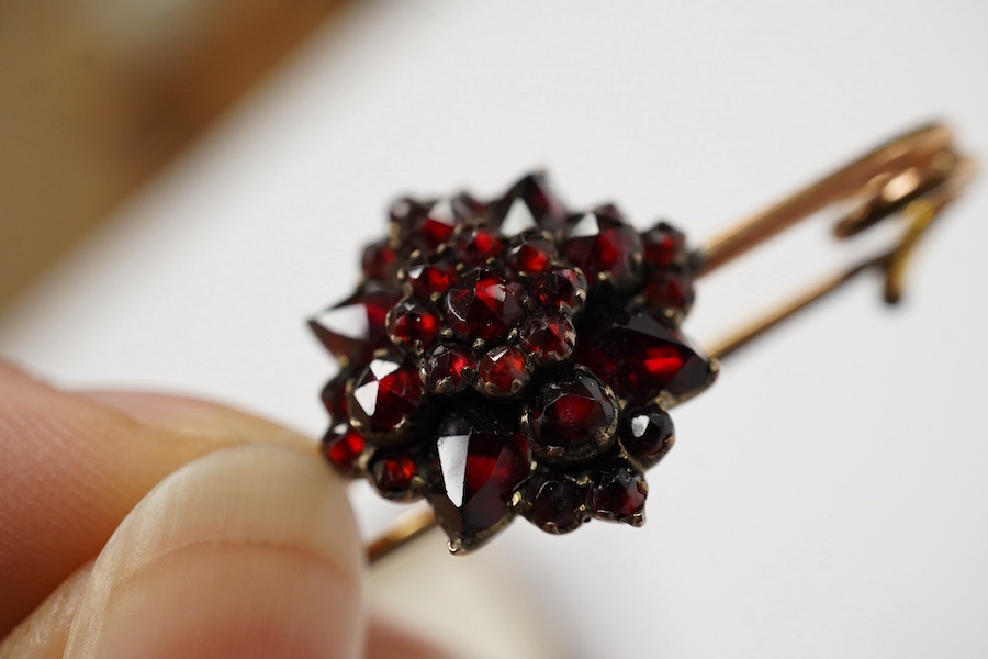 A rolled gold and garnet cluster set bar brooch, 44mm (adapted). Condition - poor to fair